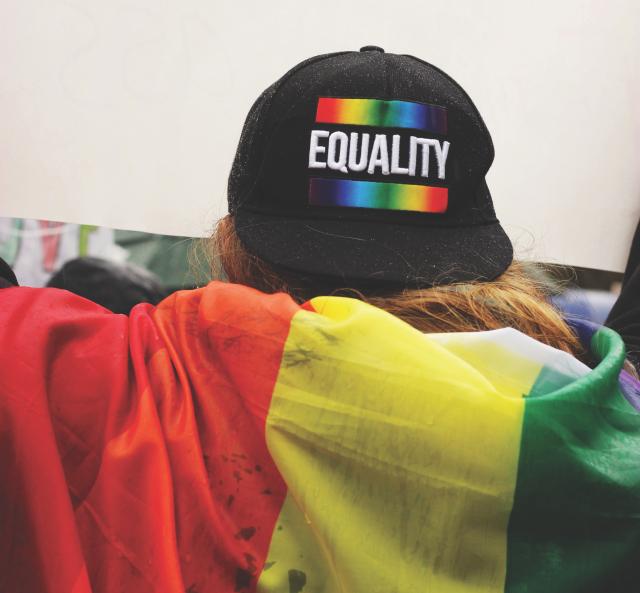 Person wearing LGBTQ+ Equality hat