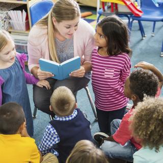 Child care worker reading to group of children